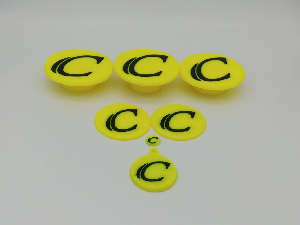 Yellow PETG C Emblems caps and keychain